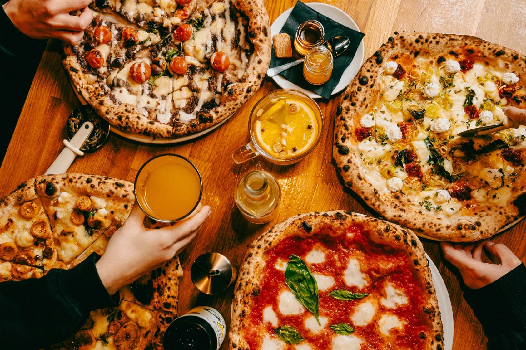 Stół zastawiony pizzami neapolitańskimi w Stacji Neapol
